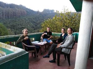 a group of people sitting in chairs on a balcony at Cool Mount Guest in Nuwara Eliya