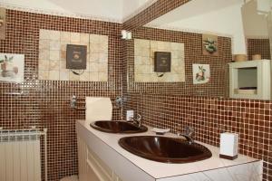 a bathroom with two sinks and a tiled wall at Chambres d'hôtes vue panoramique proche de Carcassonne in Villardonnel +26 photos