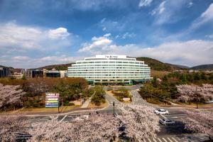 a large white building with a road in front of it at The K Hotel Gyeongju in Gyeongju