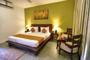 1 dormitorio con 1 cama grande y 1 silla en Tropical Life Resort and Spa, en Dambulla