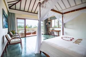 a bedroom with a white bed and a balcony at Cassia Cottage in Phu Quoc