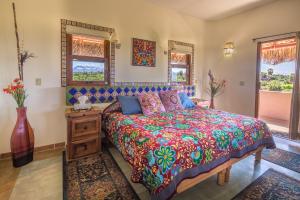 Un dormitorio con una cama con una colcha colorida. en Serendipity, en Todos Santos 50 fotos más