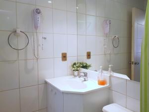 Un baño blanco con lavabo y ducha. en Apartments Zenteno, en Santiago 51 fotos más