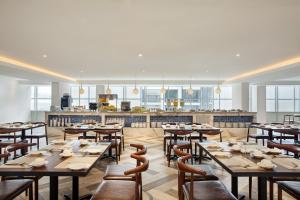 a restaurant with wooden tables and chairs and a kitchen at Days Hotel & Suites by Wyndham KL - Chan Sow Lin MRT or LRT in Kuala Lumpur