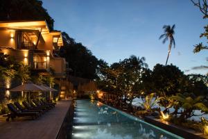 a hotel with a swimming pool at night at Maremegmeg Beach Club in El Nido