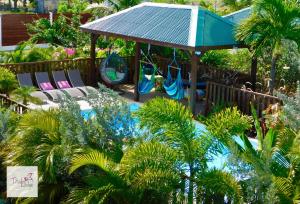 a playground with chairs and a gazebo at Titalee Lodge 3 Villas autour d'une piscine in Saint-François