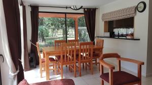 - une cuisine et une salle à manger avec une table et des chaises dans l'établissement Amplia y Cómoda Casa, à Pucón