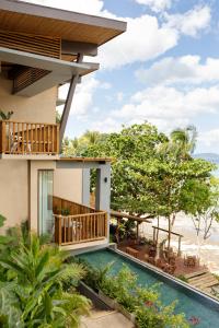a house with a swimming pool and a balcony at Maremegmeg Beach Club in El Nido
