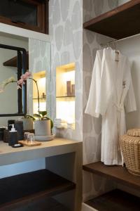 a bathroom with a white robe hanging on a shelf at Maremegmeg Beach Club in El Nido