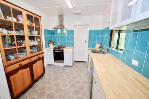 cocina con paredes de azulejos azules y encimera en Waragil Cottage - Original Settler's Home en Blackheath