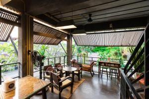 Un restaurante con mesas y sillas en un balcón. en Gord ChiangMai Hotel, en Chiang Mai
