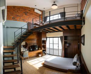 a bedroom with a bunk bed and a spiral staircase at Gord ChiangMai - SHA Extra Plus in Chiang Mai
