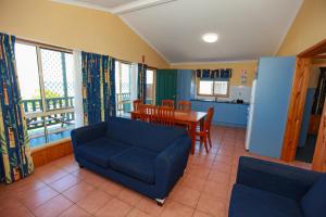 a living room with a blue couch and a table at Bulli Beach Tourist Park in Bulli