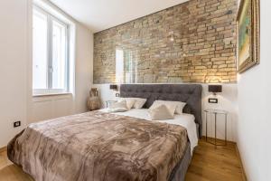 - une chambre avec un grand lit et un mur en briques dans l'établissement Queen Apartment, à Split