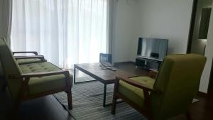 富士吉田的住宿－Cortege，带沙发、桌子和电视的客厅