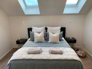 a bedroom with a large bed with pillows and windows at 112 Rural View in Cambridge