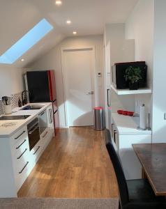 uma cozinha com armários brancos, um lavatório e um micro-ondas em 112 Rural View em Cambridge