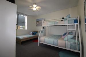 a bedroom with two bunk beds and a ceiling fan at Main Break 1, 1 Main Street, in Crescent Head