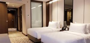 Postel nebo postele na pokoji v ubytování Wyndham Opi Hotel Palembang