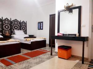 カイロにあるArabian Nights Pyramids Guesthouseのベッド2台、鏡、シンクが備わる客室です。
