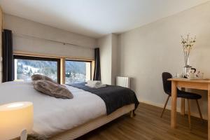 um quarto com uma cama, uma secretária e uma janela em Résidence Grand Roc - Campanules 411 - Happy Rentals em Chamonix-Mont-Blanc