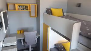 a bedroom with a desk and a bunk bed at APARTAMENT ELEGANCE YELLOW in Rewal