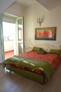 1 dormitorio con 1 cama grande con colcha roja en Residence Onda Etrusca, en San Vincenzo