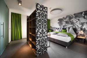 a bedroom with a bed and a green wall at Hotel Greenrooms in Graz