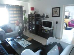 a living room with a couch and a tv at Luxury Living Apartment in Hammamet