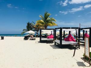 a group of beds on a sandy beach at CondoHotel 5th Avenue Std Double Studio in Playa del Carmen