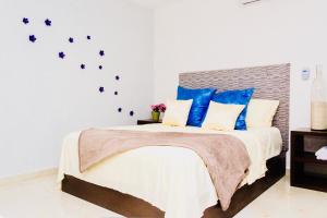 a bedroom with a large bed with blue pillows at CondoHotel 5th Avenue Std Double Studio in Playa del Carmen