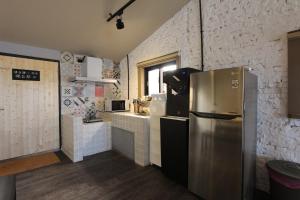 Una cocina con refrigerador de acero inoxidable en una habitación. en Grass Villa, en Eluan