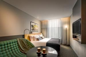 シドニーにあるVeriu Green Squareのベッドとソファ付きのホテルルーム
