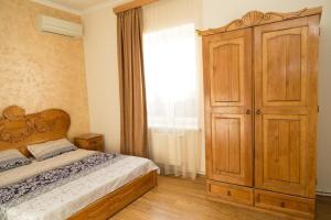 um quarto com uma cama e um armário de madeira em Cozy Apartment With The Best Patio and Swimming pool em Yerevan mais 30 fotografias