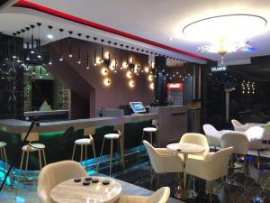 um restaurante com cadeiras brancas e um bar em Qu Lin Resident em Sibu