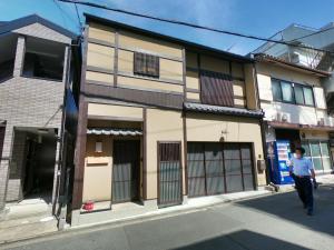a man walking down a street in front of a building at Shibashi Umeyacho in Kyoto