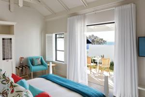 a bedroom with a bed and a view of the ocean at The Old Rectory in Plettenberg Bay
