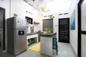 a kitchen with a refrigerator and a chalkboard on the wall at Stay SongSong Mount Erskine in George Town