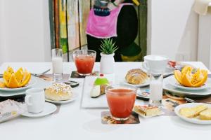 een tafel met borden met eten en drinken bij Afea Art & Rooms in Palermo