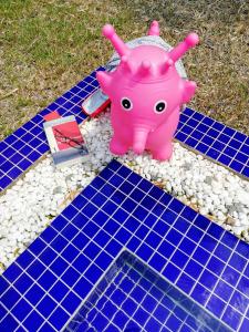 a pink pig toy sitting on a blue tiled floor at Villa b.Maison d'Hôtes Angkor in Siem Reap