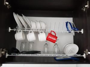 a kitchen with dishes and utensils on a shelf at Apartasuites Medellin Los Molinos in Medellín