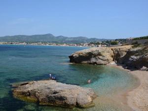two people in the water on a beach with rocks at Cap Negre villa in Six-Fours-les-Plages