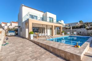 a villa with a swimming pool and a house at Platanias Villa Mirsini in Plataniás