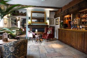 a restaurant with a bar and a table and chairs at The King's Head by Innkeeper's Collection in Wellesbourne Hastings