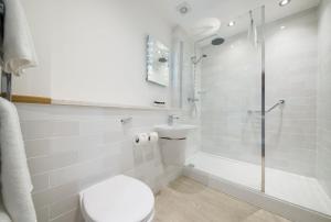 a white bathroom with a toilet and a shower at The King's Head by Innkeeper's Collection in Wellesbourne Hastings