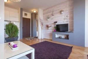 a living room with a white table and a tv at VIOLET APARTMENT in Skopje