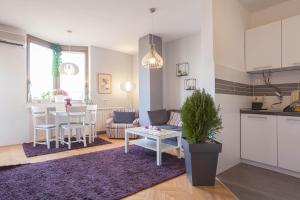 a kitchen and a living room with a table and a couch at VIOLET APARTMENT in Skopje +7 photos