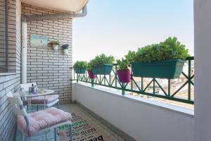 a balcony with potted plants and a table and chairs at VIOLET APARTMENT in Skopje