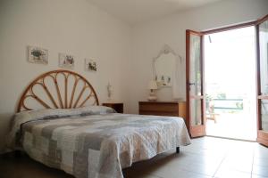 Padulella Mare by HelloElba في بورتوفيرّايو: غرفة نوم بسرير وباب زجاجي منزلق كبير