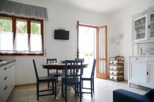 una cucina e una sala da pranzo con tavolo e sedie di Padulella Mare by HelloElba a Portoferraio